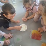 dzieci patrzą jak chłopiec wlewa zieloną fabrę do miski.jpg