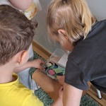 dzieci oglądają kolorowe magnesy w pudełku.jpg