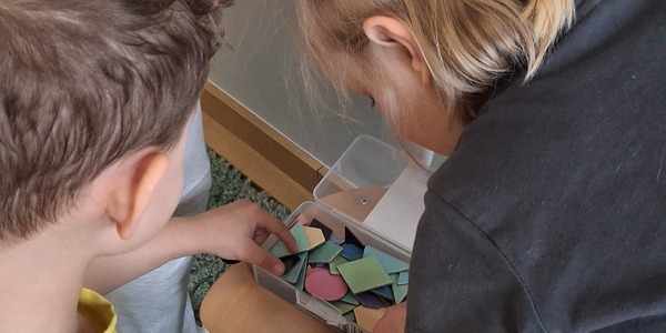 dzieci oglądają kolorowe magnesy w pudełku.jpg