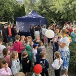 dzieci stoją na chodniku pani trzy6ma biały balon.jpeg