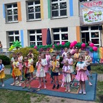 dzieci stoją na dywanie z kolorowymi kwiatami na szyji.jpeg