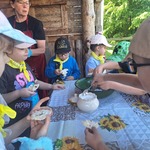 dzieci stoją przy stole i posypują cukrem pudrem ciasteczka.jpg