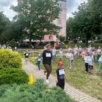 dzieci stoją na trawie i kibicują dzieciom które biegną po chodniku.jpg