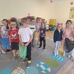 dzieci stoją na dywanie i trzymają kolorowe worki na śmieci.jpg