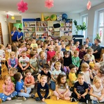 dzieci siedzą na dywanie i na krzesłach.jpeg
