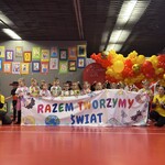 dzieci stoją za kolorowym plakatem.jpg